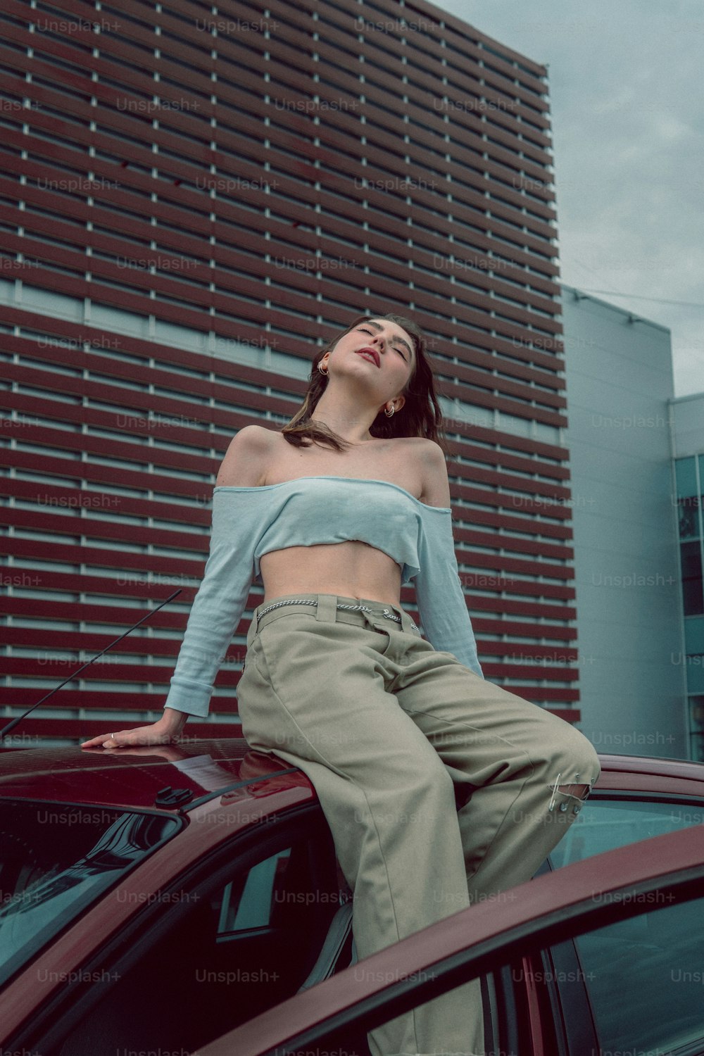 a person sitting on the hood of a car