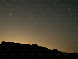 Un cielo nocturno estrellado sobre una cadena montañosa