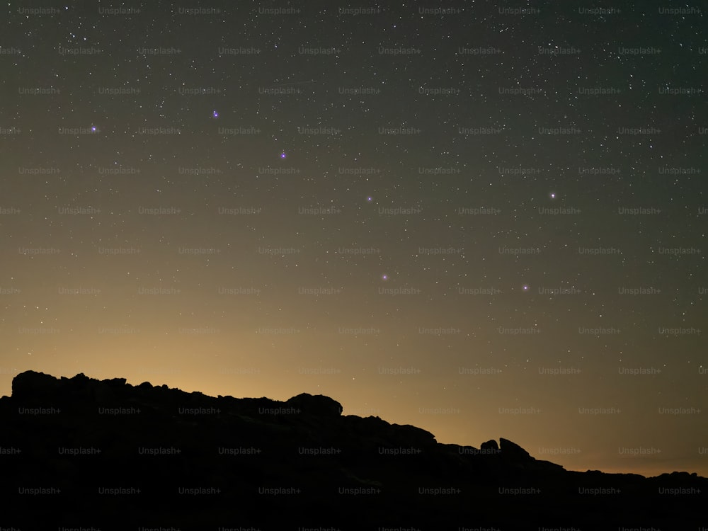 a starry night sky over a mountain range