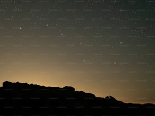 a starry night sky over a mountain range