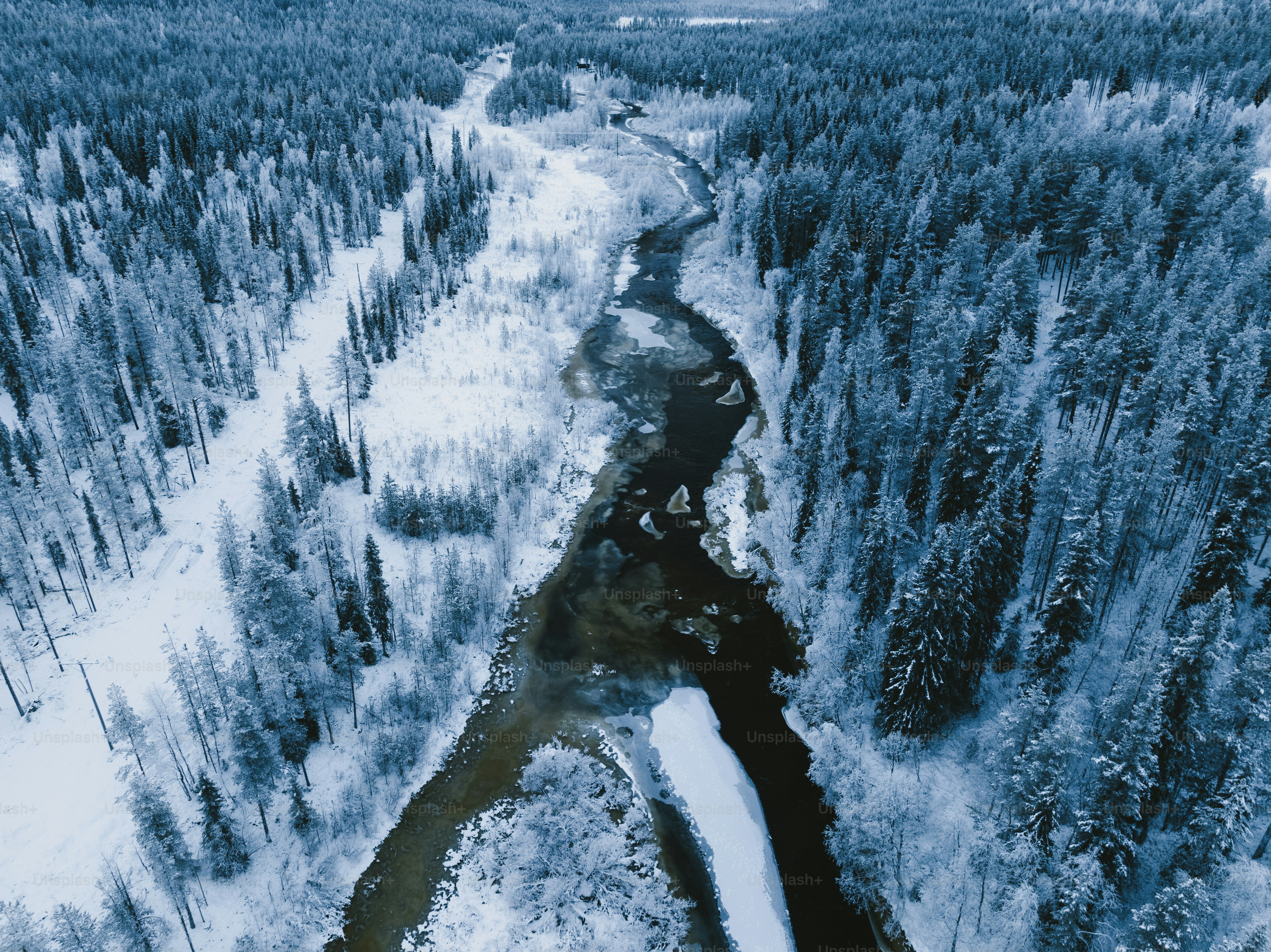 a snowy mountain with a river running through it