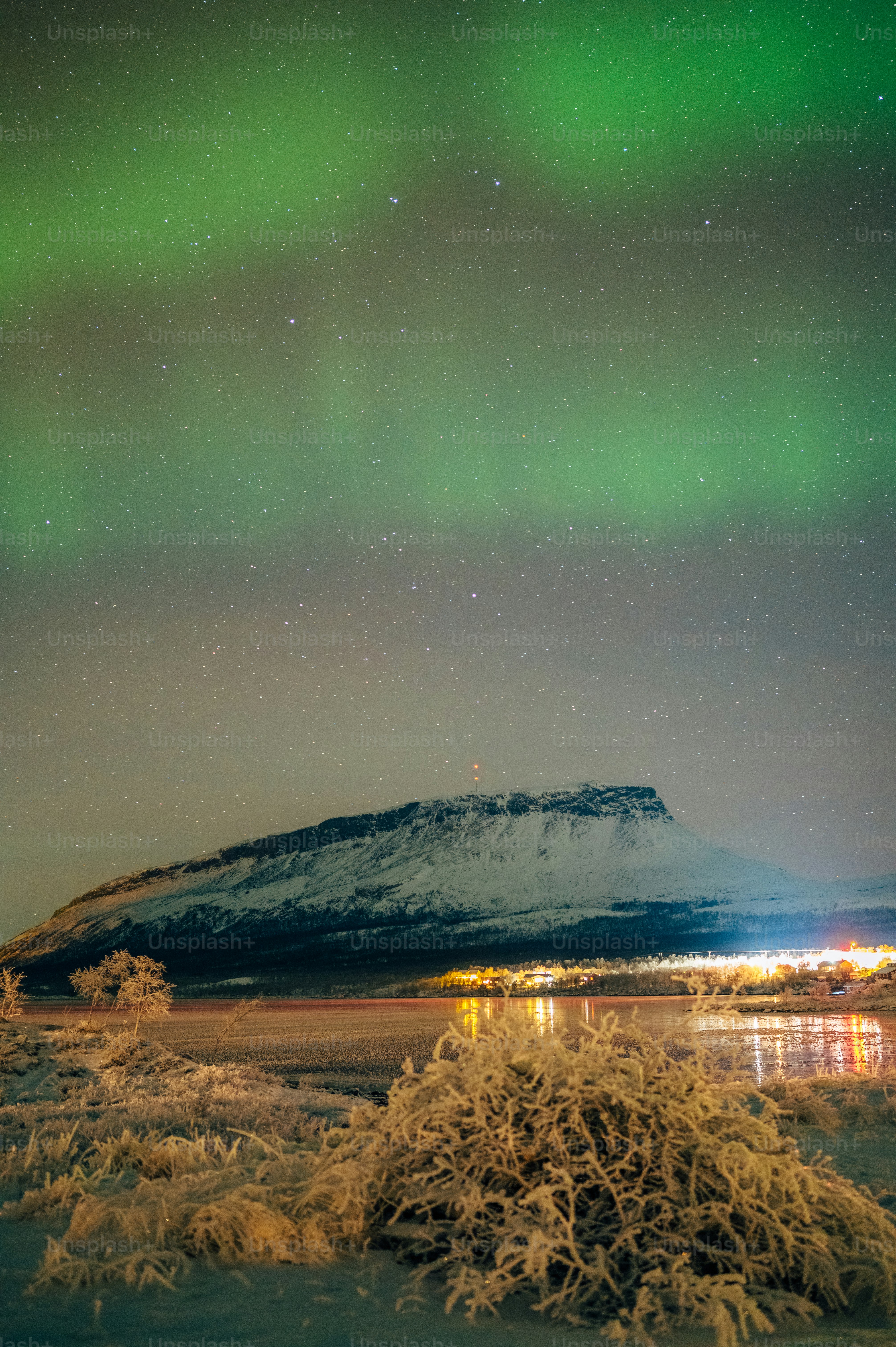 a snowy mountain and a body of water at night