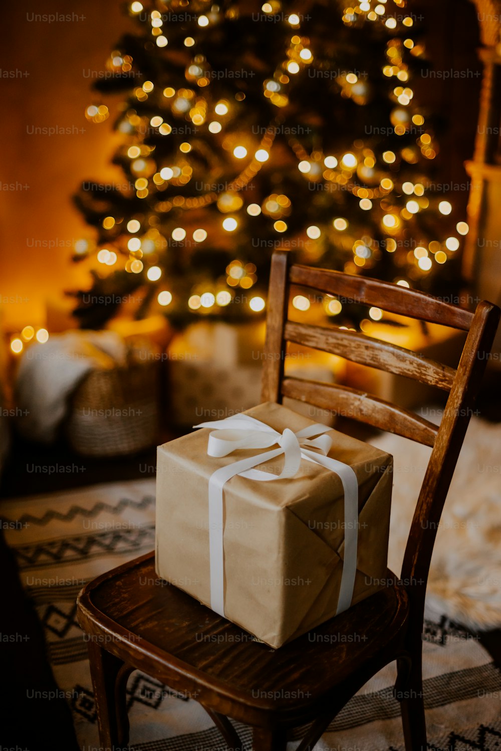 Una silla con una caja frente a un árbol de Navidad
