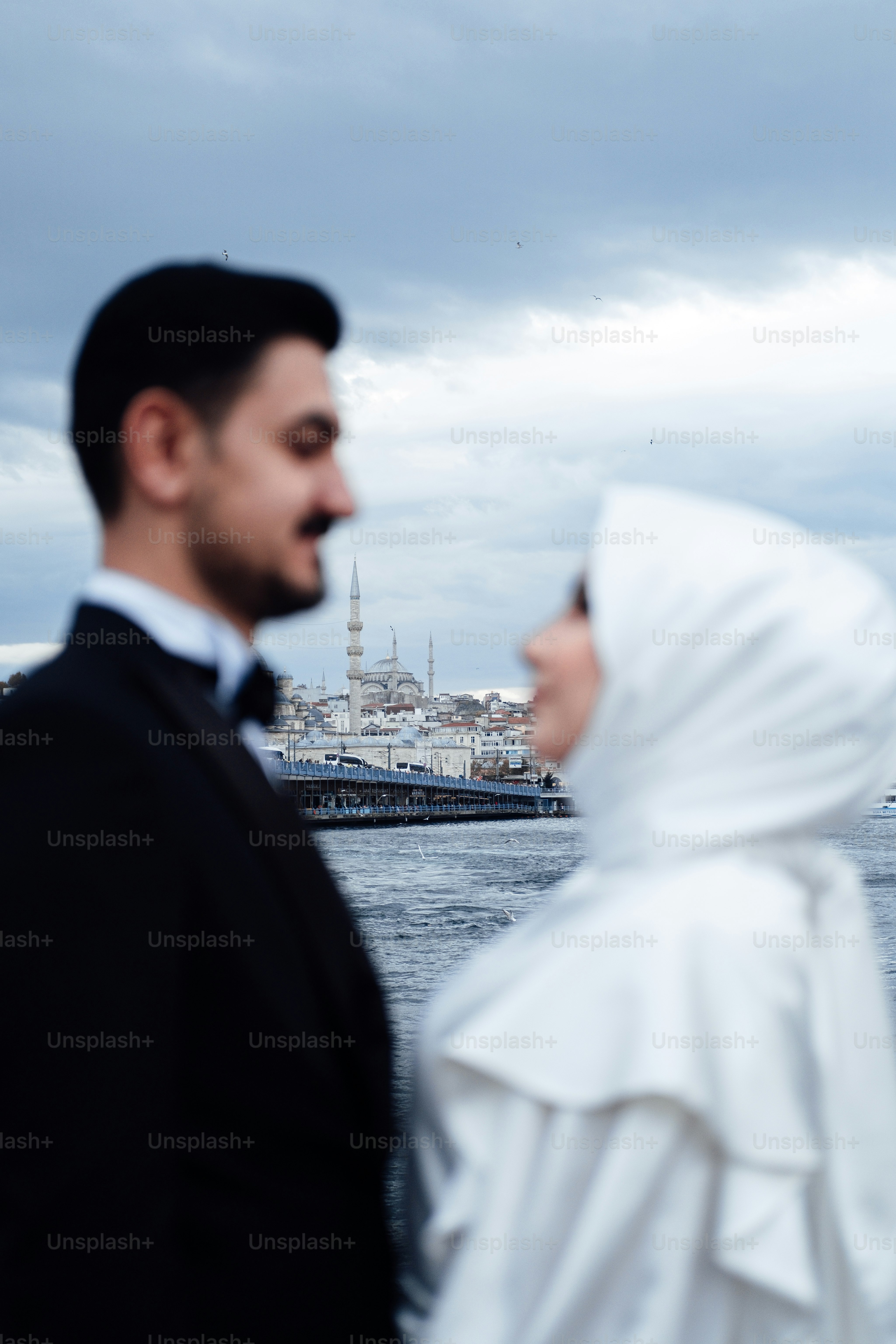 a man in a suit and tie standing next to a man in a white turban