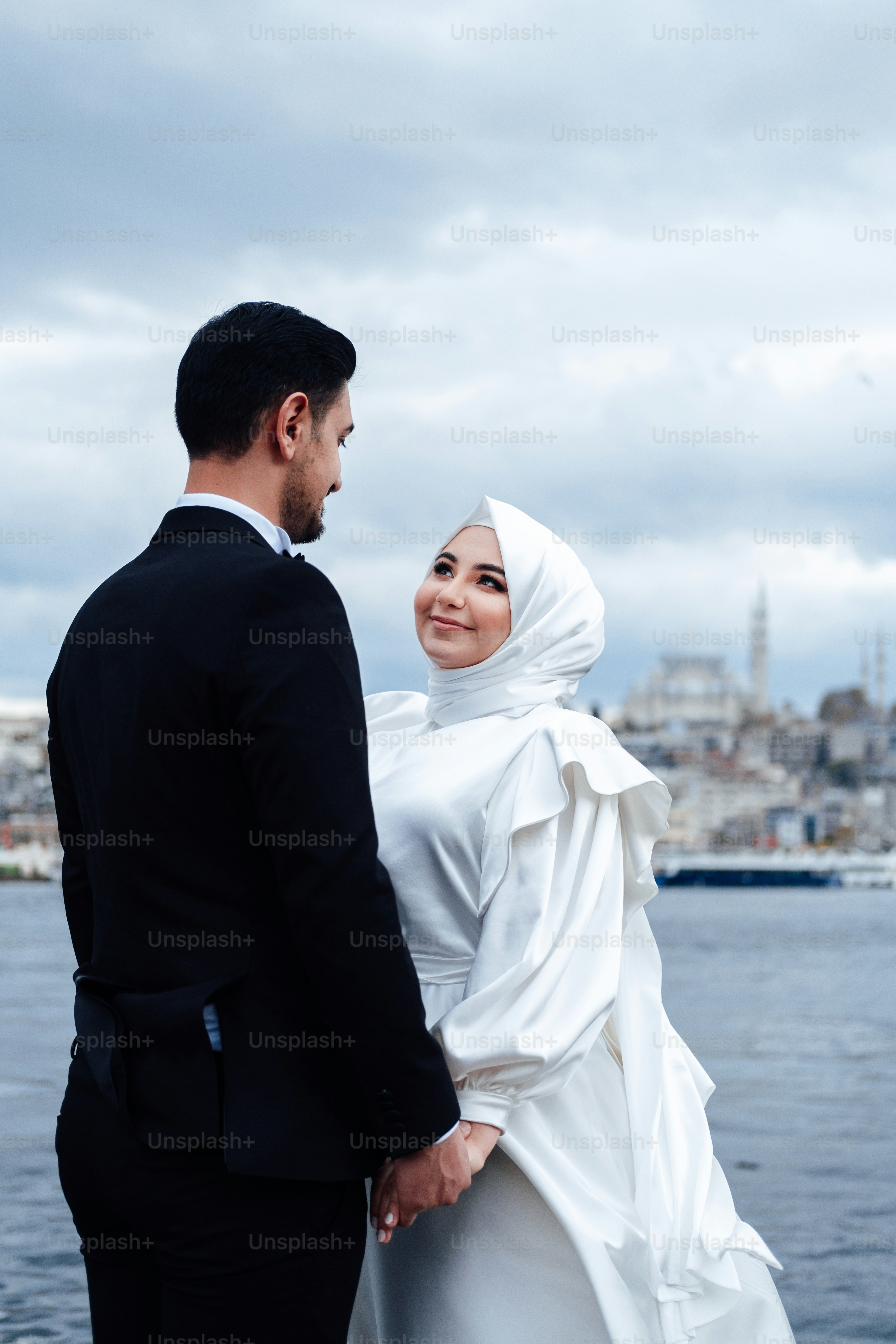 a man and woman standing next to each other and looking at each other