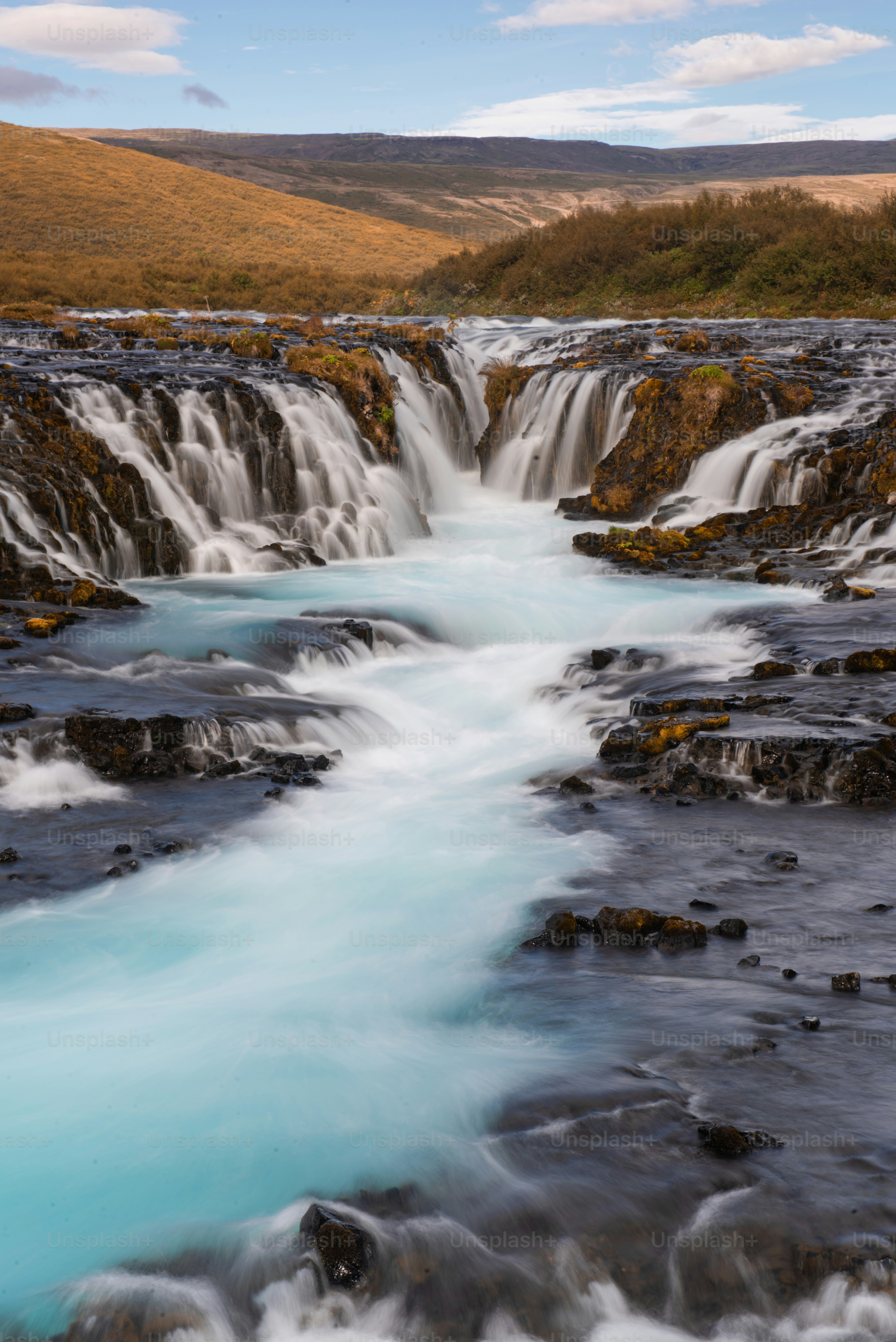a waterfall with a rocky cliff in the background