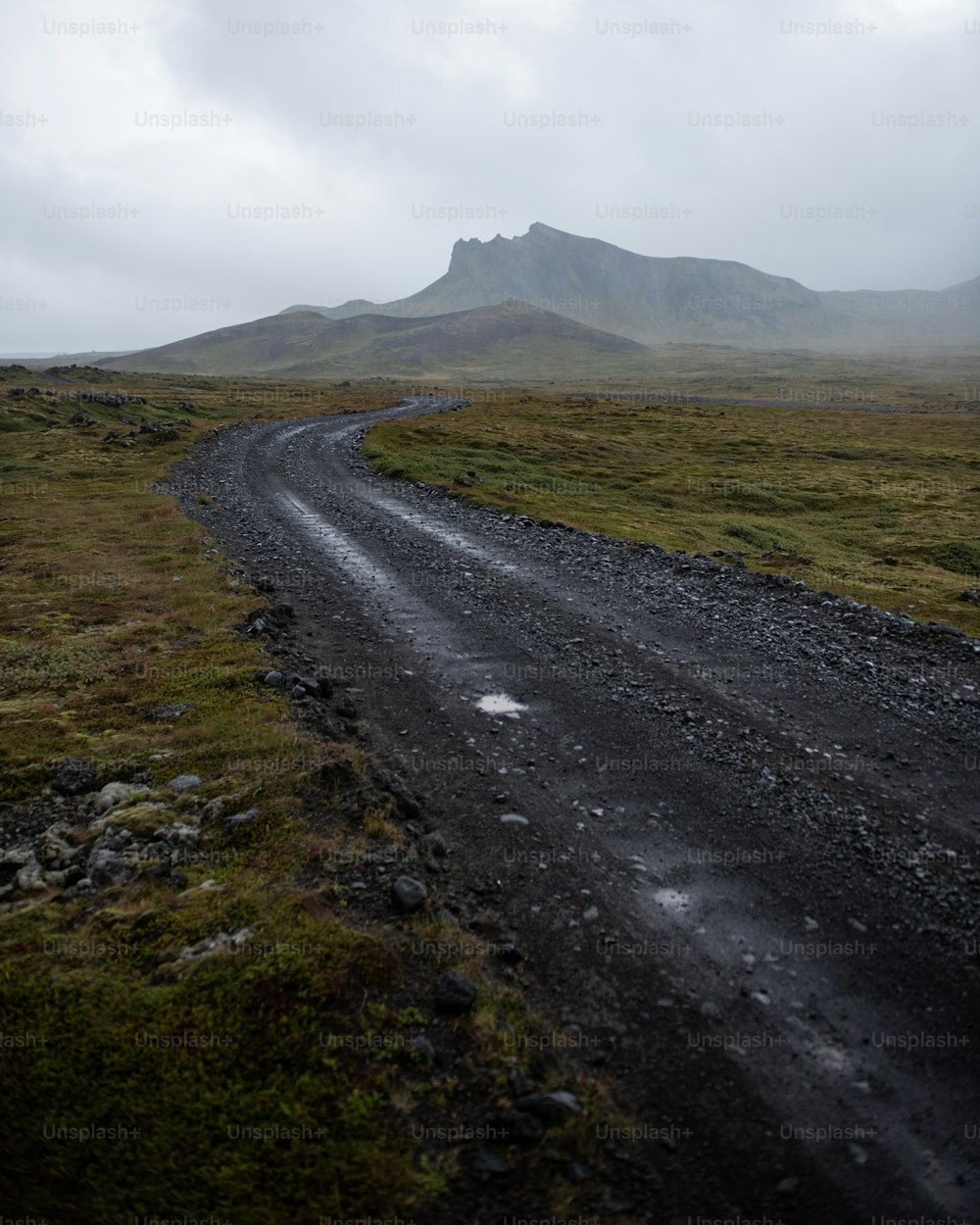 a road with grass and rocks on the side