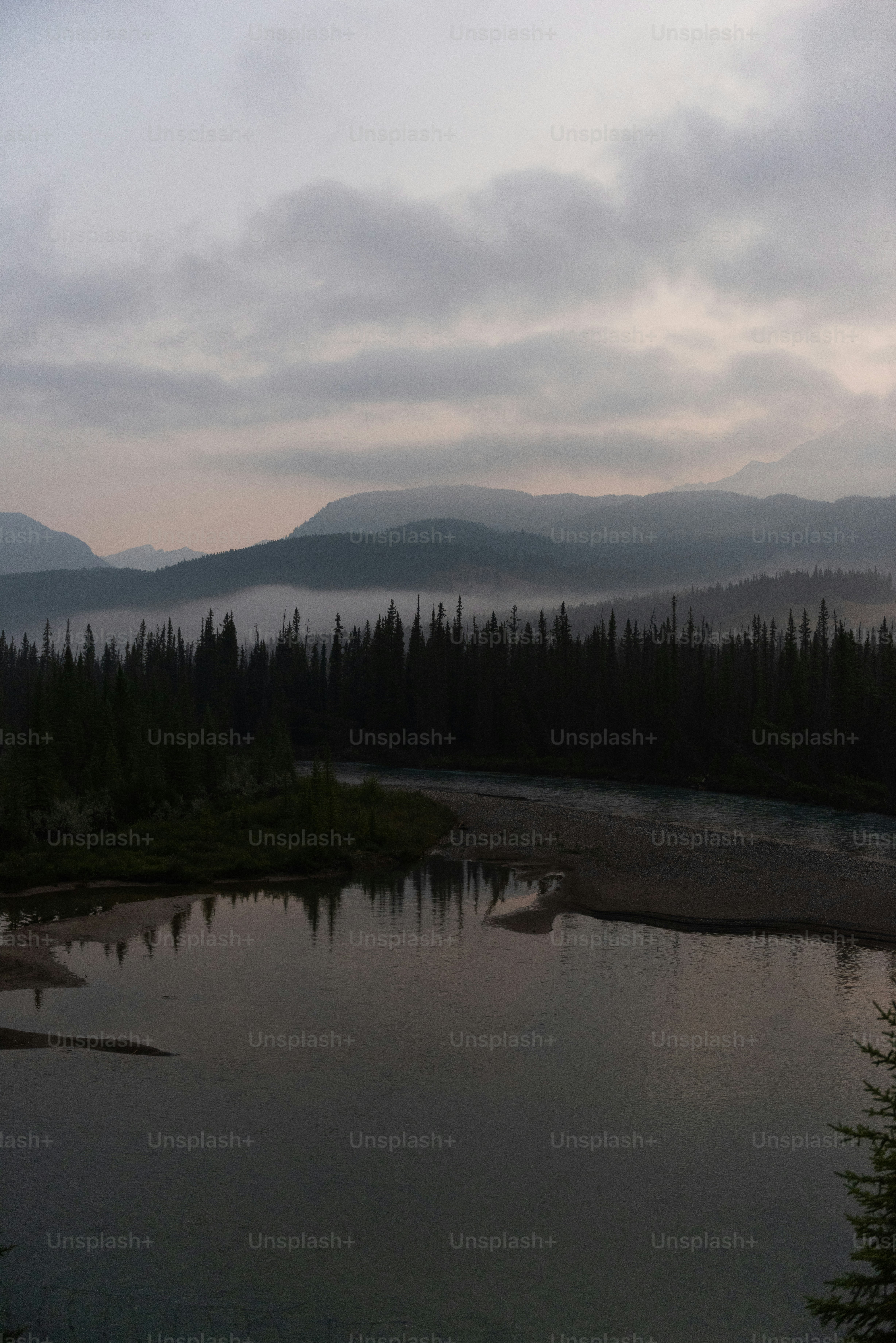 a lake surrounded by trees and mountains