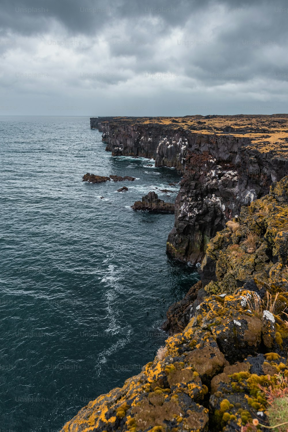 a rocky cliff next to a body of water