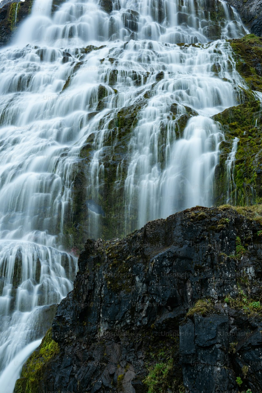 a waterfall with rocks and moss