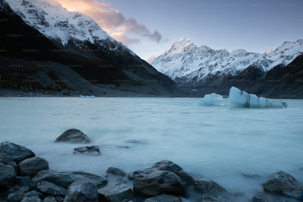 a body of water with ice and snow on the side