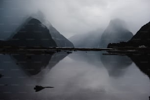 a body of water with mountains in the background with Milford Sound in the background