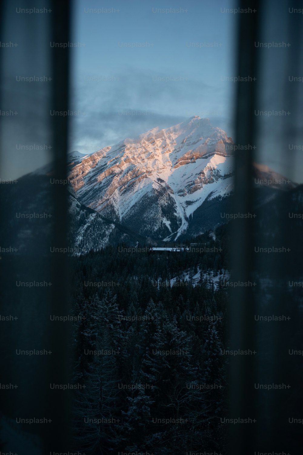 uma janela com uma montanha no fundo