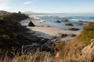 a rocky beach with a body of water in the background