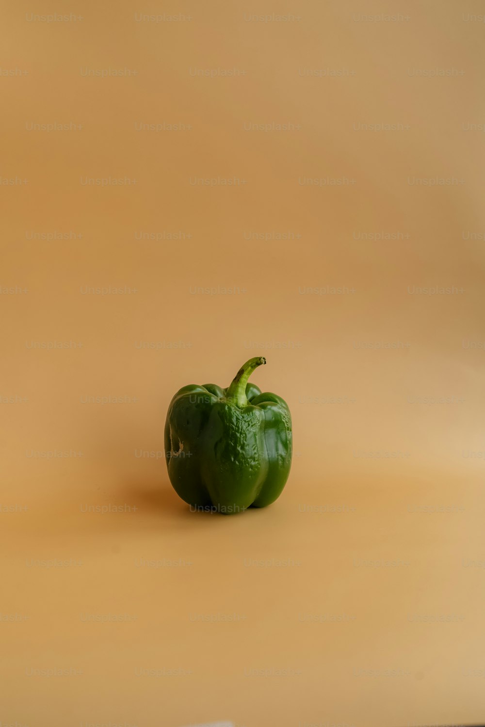 a green pepper on a white surface