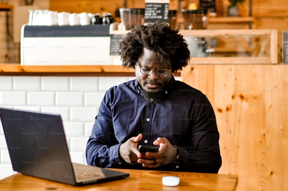 Un homme assis à un bureau avec un ordinateur portable et un téléphone