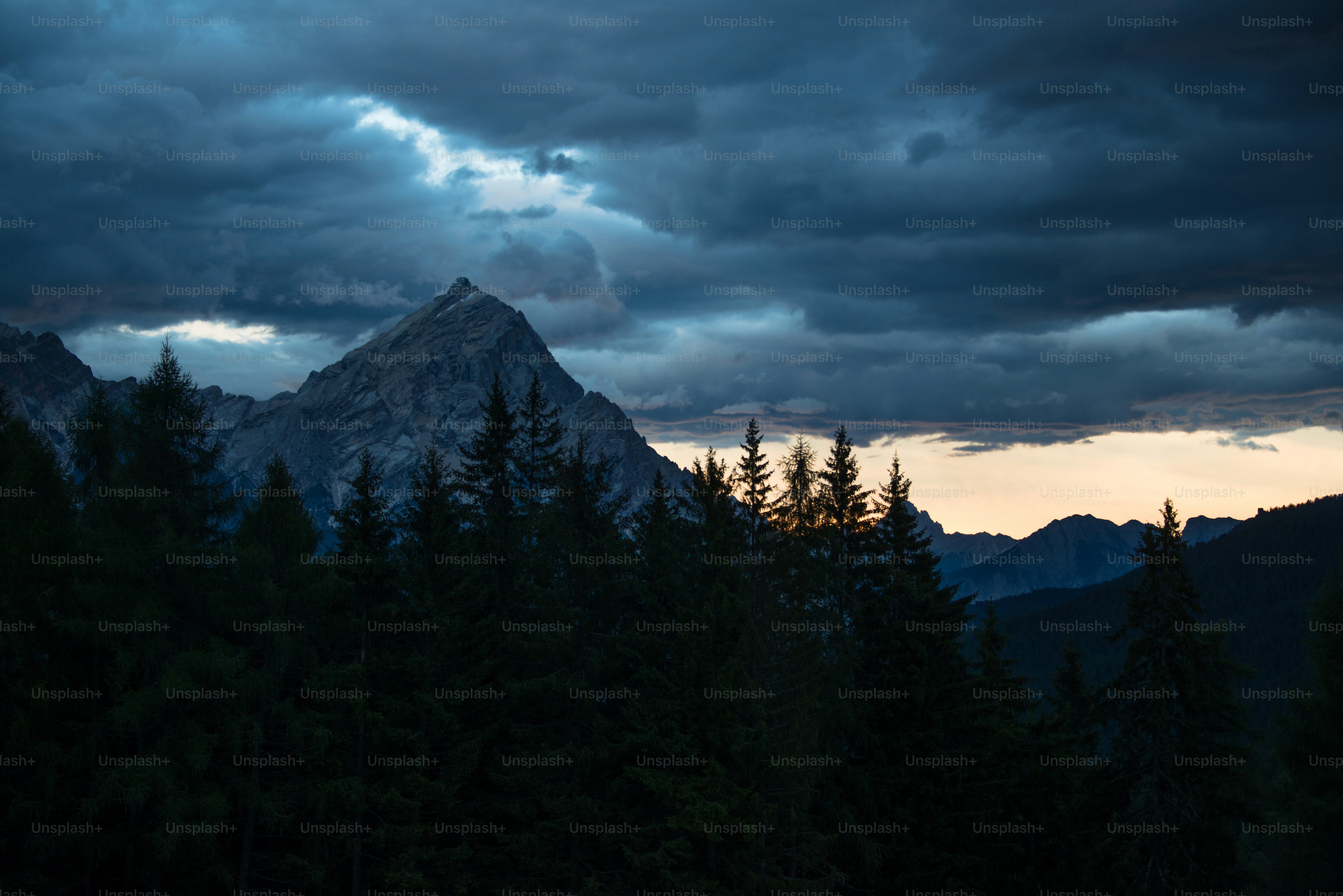 a mountain with trees and clouds