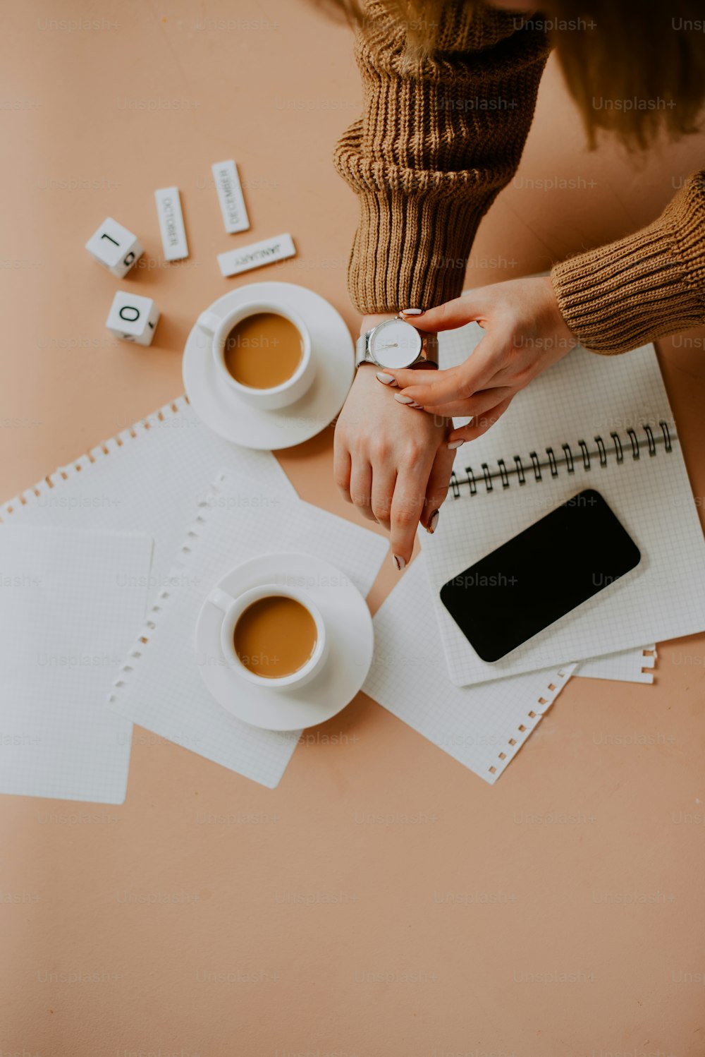 a person holding a phone and a cup of coffee