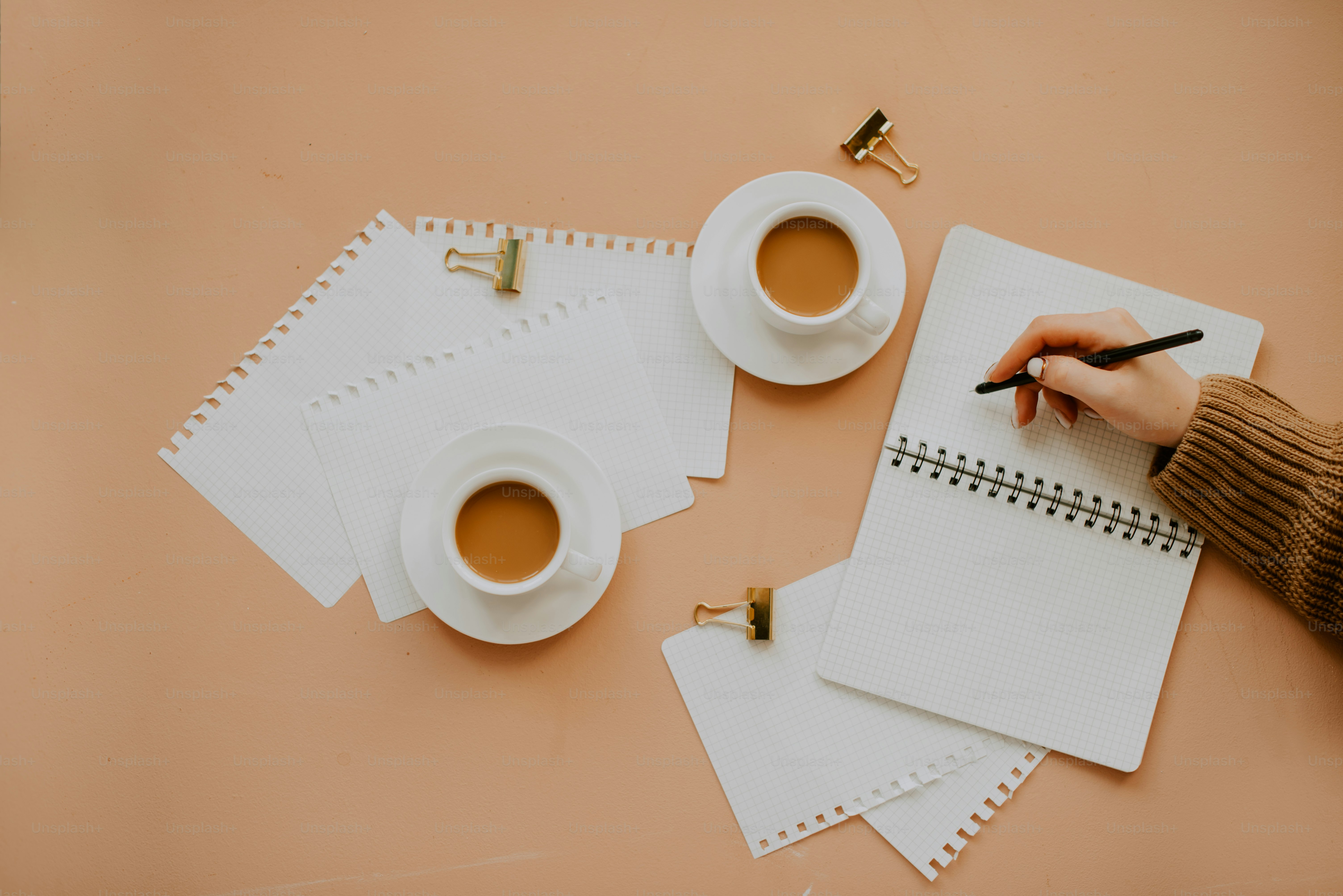 a table with a few cups and a pen and a paper with a cup and a straw