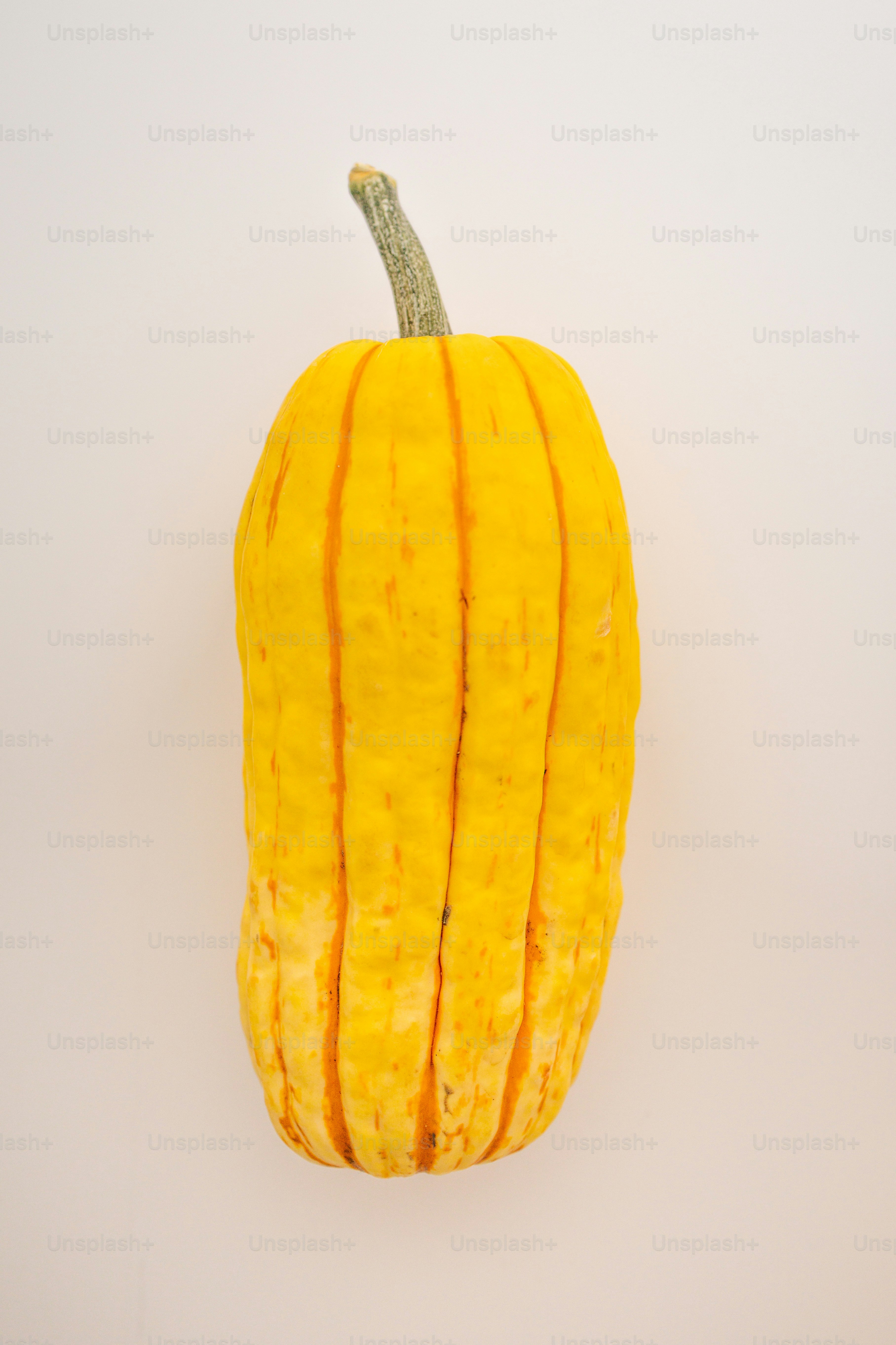 a yellow squash with a stem