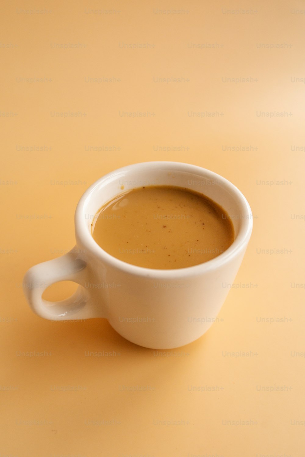 a white cup with brown liquid