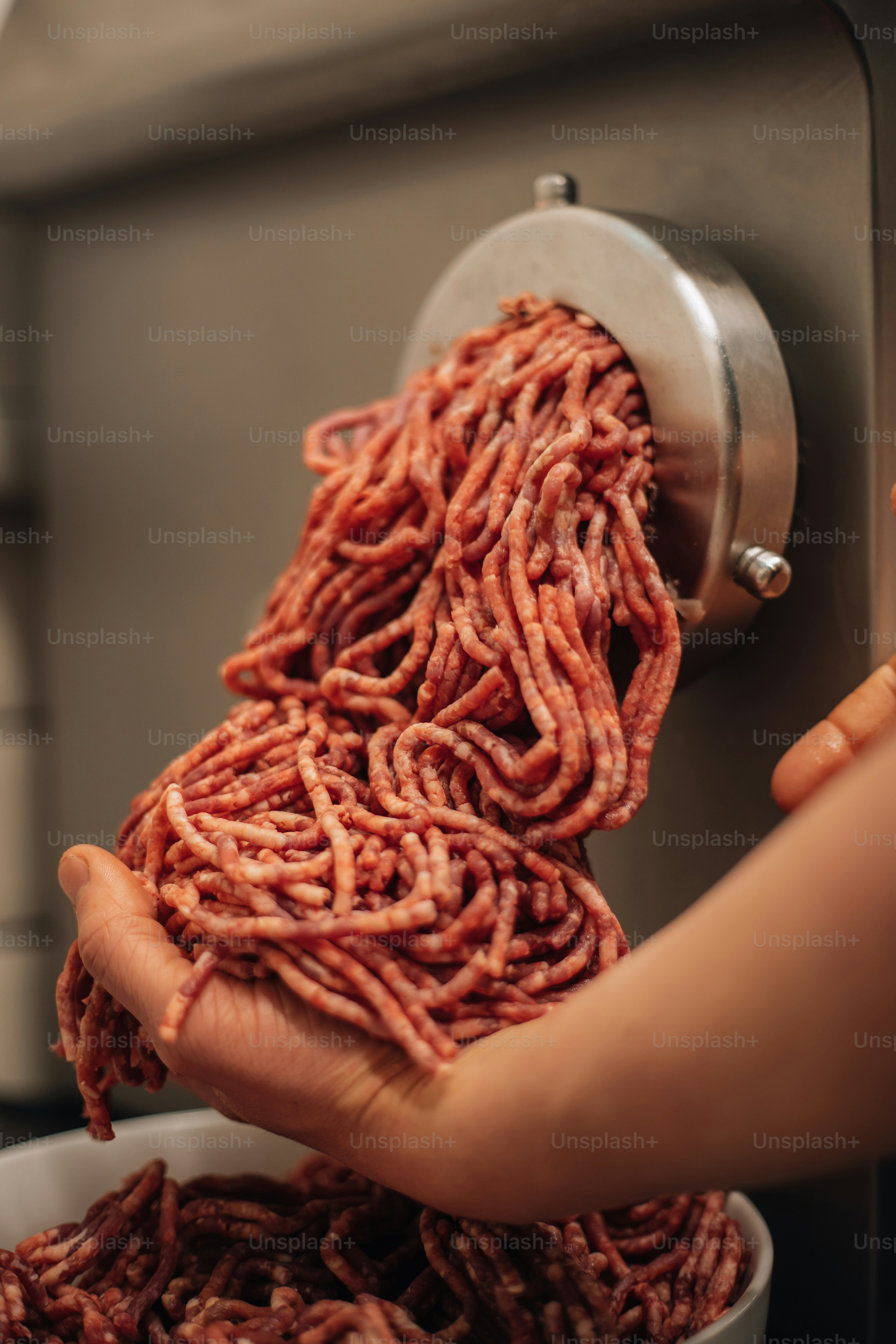 금속 손잡이가 달린 빨간색과 흰색 물체를 들고 있는 손