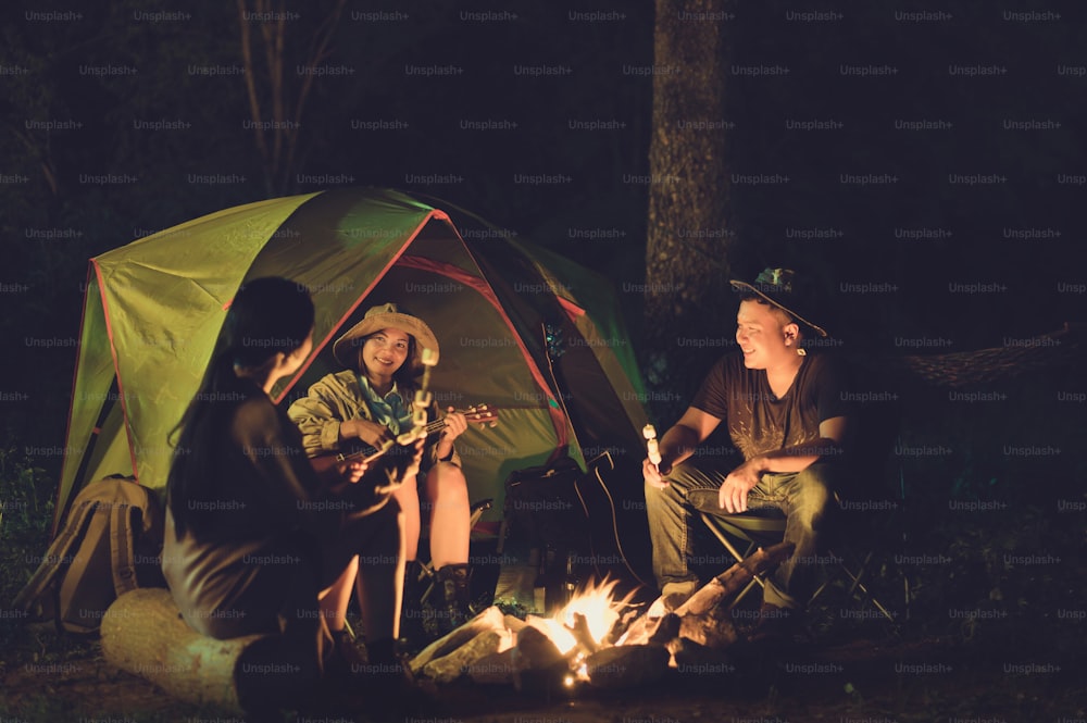 친구들은 밤에 캠핑을하고 있습니다.