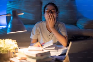 Asian woman tired from working at home She felt sleepy yawning.