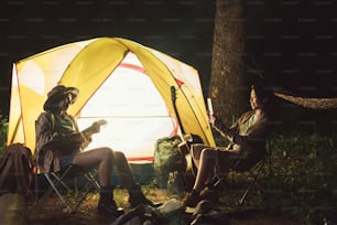 Friends are camping in the night.