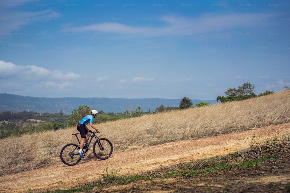 Mountain biker cycling, training and going up a steep climb.