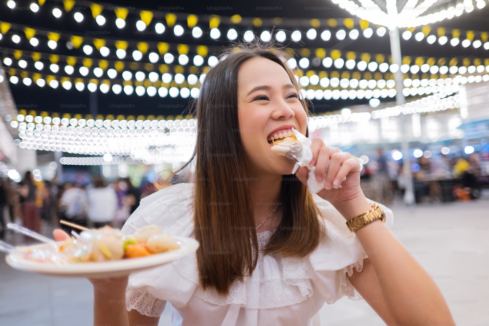 Asian woman tourists eat street food Thailand in the evening