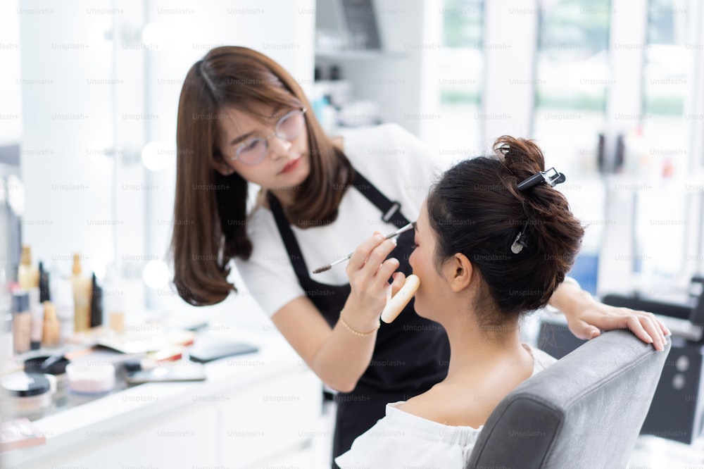 Asian beauticians are doing makeup for customers.
