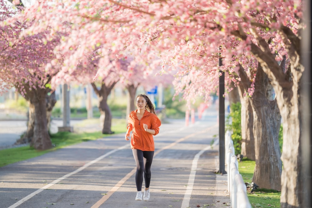 아침에 아시아 여성 운동 그녀는 사쿠라 공원에서 달리고 있습니다.