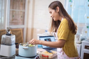 Asian woman Cooking lunch in the kitchen She is doing suki