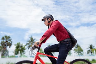 Asian man is cycling to work in the morning.