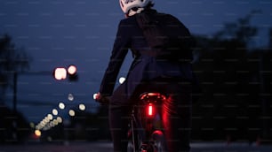 Homens asiáticos em bicicletas de volta do trabalho à noite. Ele parou nos semáforos.