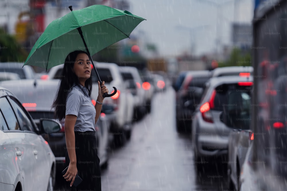 Mujeres asiáticas usan paraguas caminando por la calle mientras llueve