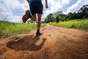 Shoes from behind men he is running a trail. In the natural path