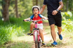 Vater nimmt Kinder mit, um Radfahren zu üben.