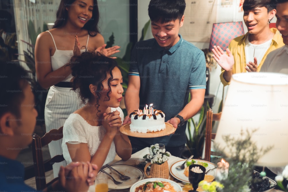 Asian friends group Celebrating at a birthday party She is blowing candles