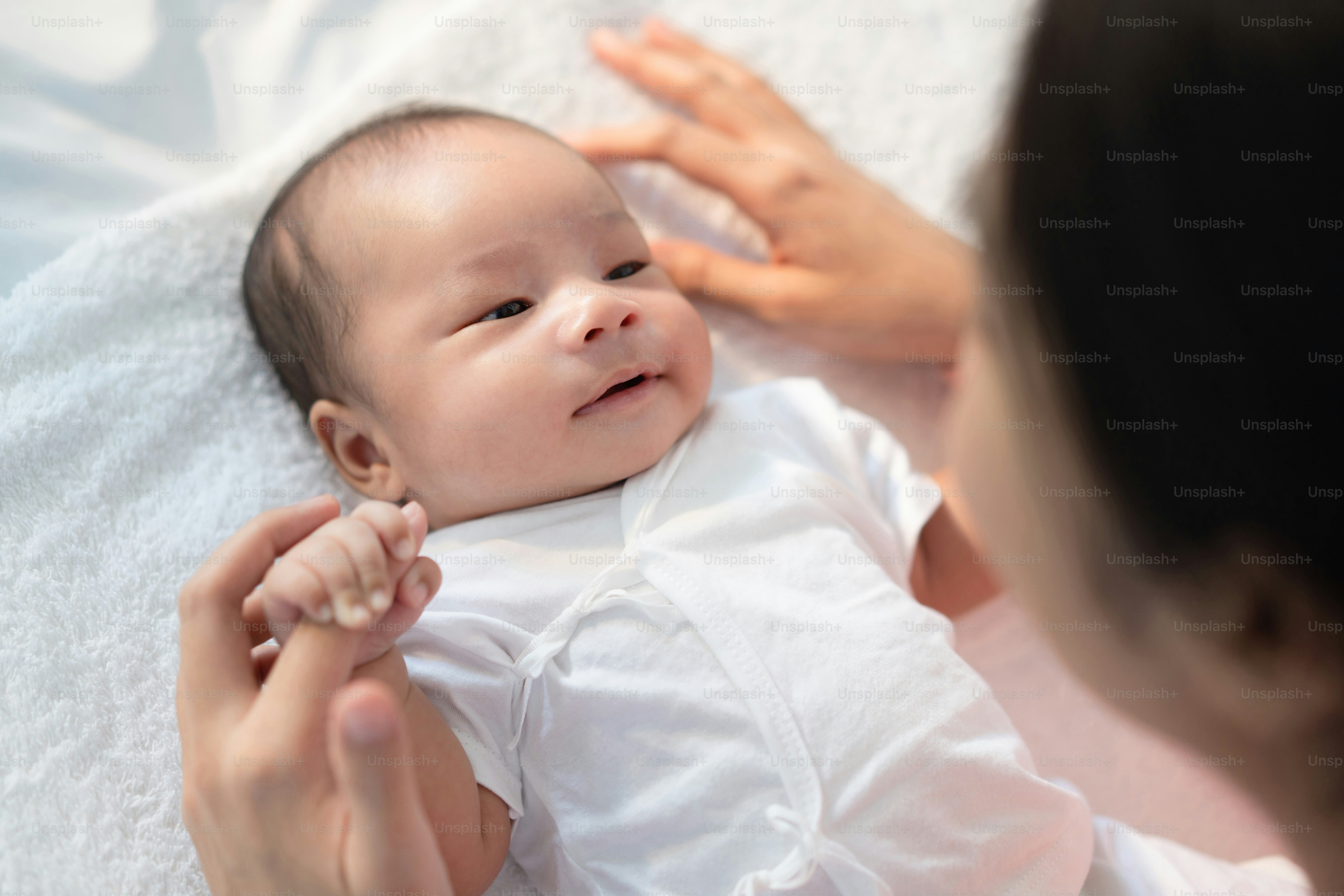 Newborn baby talking to mom hold the finger of mom