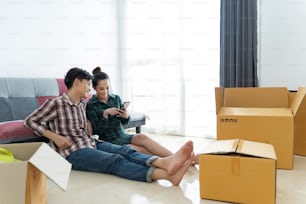 Asian couples are moving home. They're open in boxes.They are watching the phone.