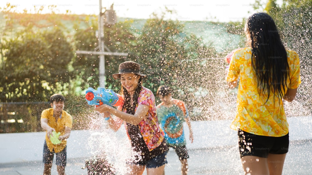 Gli asiatici usano pistole ad acqua suonano il festival songkran in estate aprile