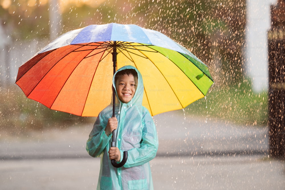 Asiatischer Junge mit Regenschirm.
