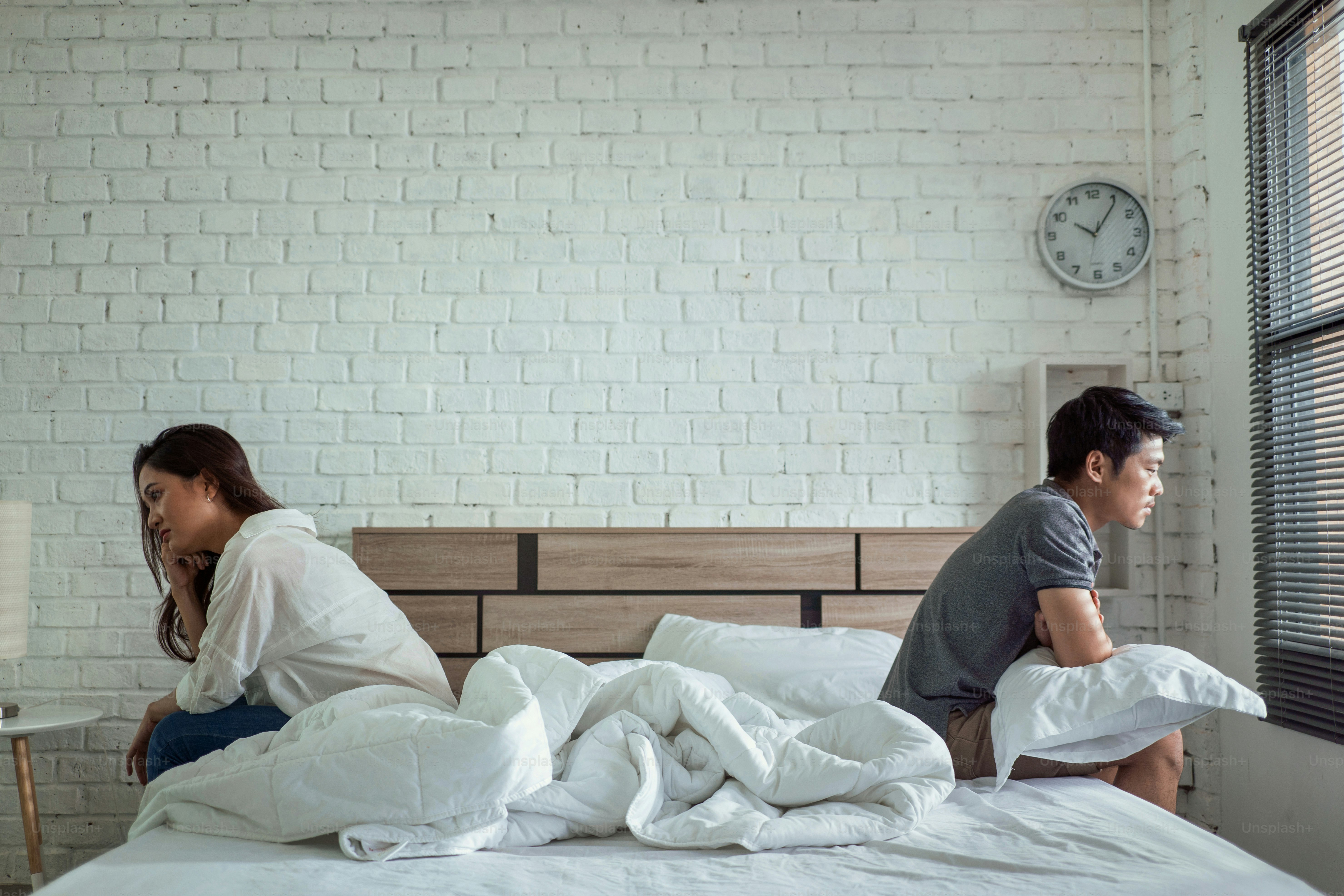 Asian couples quarrel sit in bed ,they argue not to talk to each other. They are unhappy