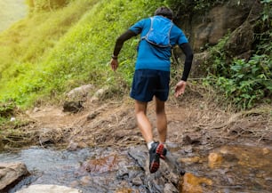 Runner, he's running a trail. In a natural path with a stream