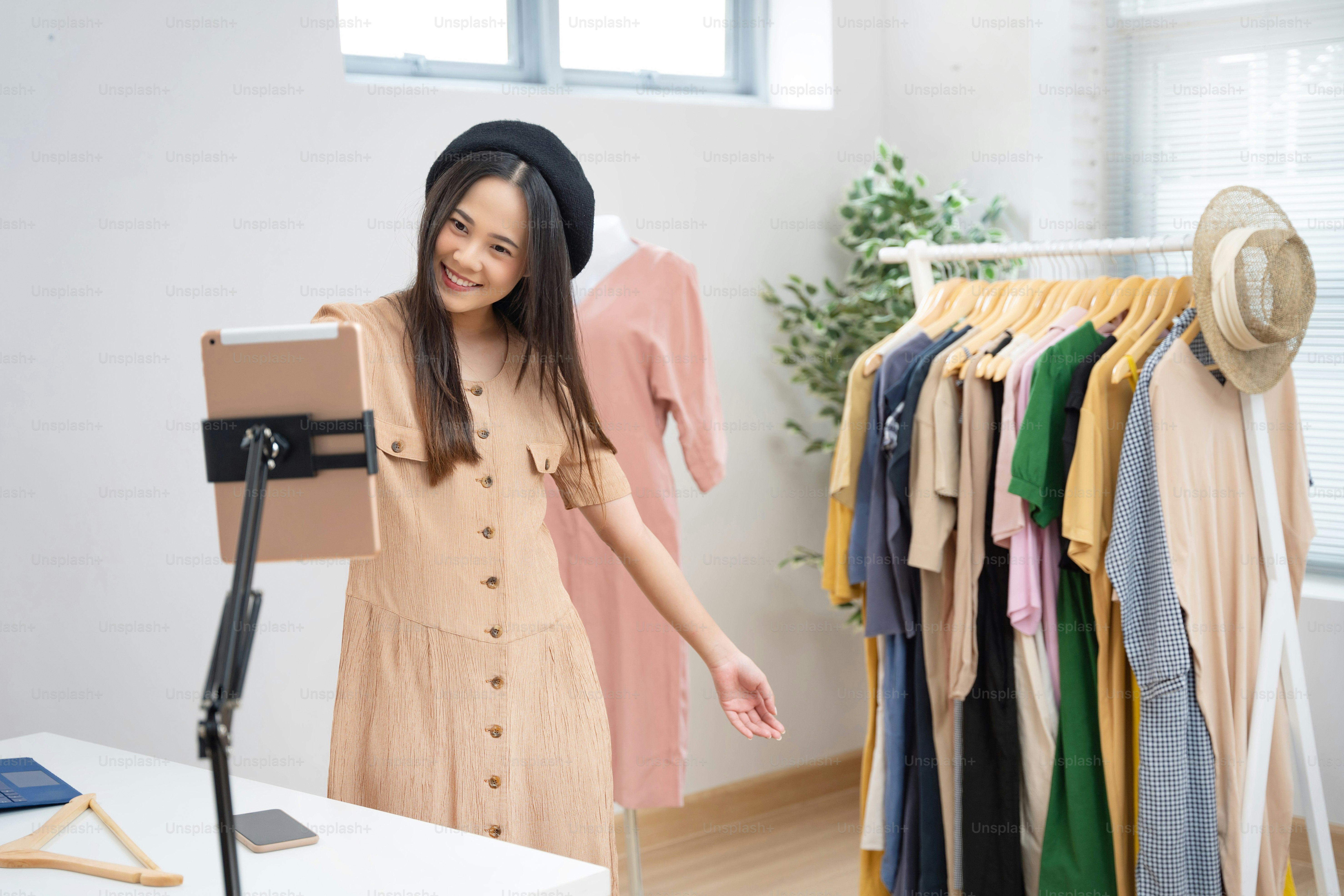 Asian woman selling vintage clothes, she is live on social media.