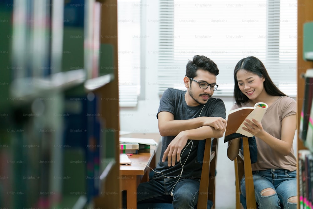 Estudantes asiáticos Ajudando uns aos outros a estudar o conhecimento na biblioteca