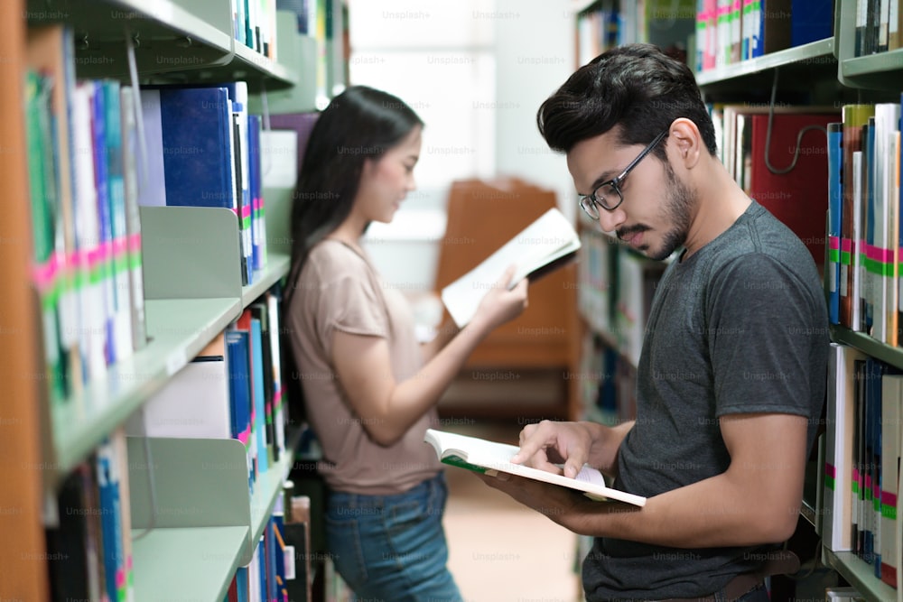 Estudiantes asiáticos leyendo en las estanterías