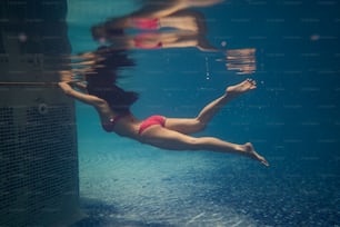 In piscina, le donne asiatiche si tuffano. Aveva un bikini.